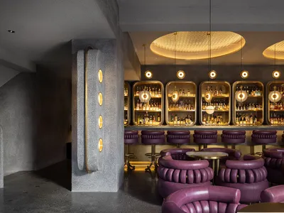A modern restaurant bar with concrete and metal finishes.