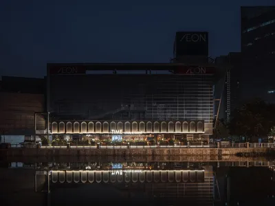 Modern restaurant with glass exterior and illuminated signage at night.