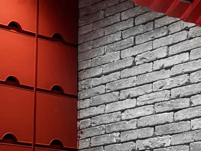 Modern restaurant interior with brick and concrete walls featuring red accents.