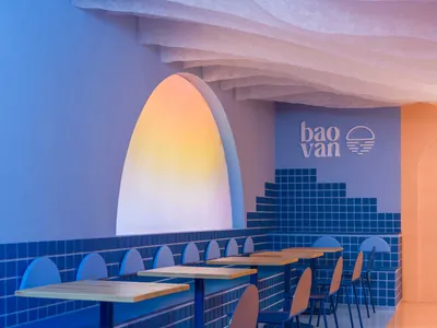 Modern restaurant interior with blue ceramic walls and tables.