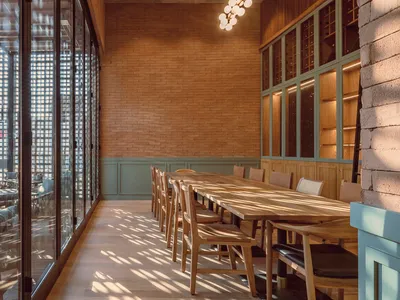 Modern restaurant dining room with wooden furniture and brick walls
