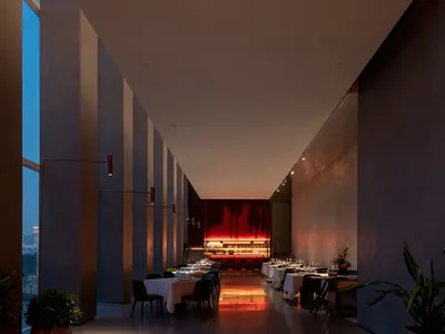 A modern restaurant interior with red walls and white tables.