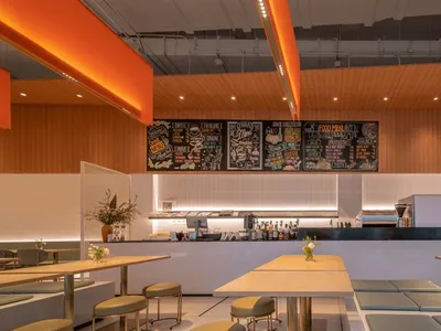 Modern cafe interior with tables, chairs, and menu board