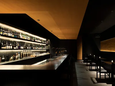 Industrial-style restaurant interior with wooden walls, glass counter, and tiled bar area.