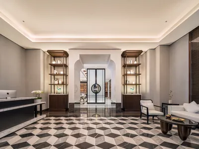 A minimalist hotel lobby featuring marble and glass materials