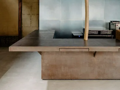 Modern kitchen interior featuring wooden and concrete surfaces with metal accents.