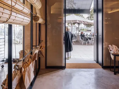 Industrial restaurant entrance with glass, concrete, and brick materials