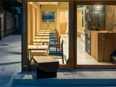 Modern restaurant interior with wooden tables and chairs.