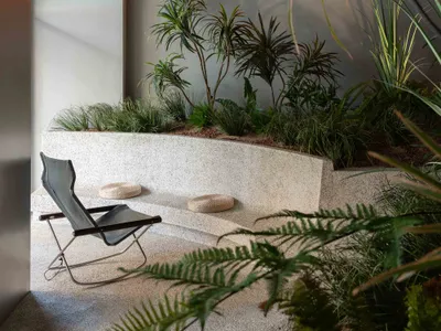 A minimalist industrial restaurant interior featuring concrete flooring and a terrazzo counter top.