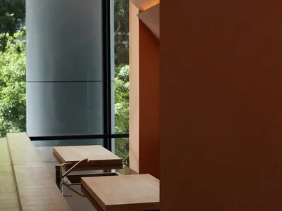 A modern kitchen interior featuring wooden countertops and concrete walls with ambient lighting