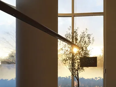 A modern restaurant dining room with a long wooden table, chairs, and place settings, featuring a large window with a view of