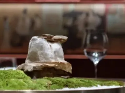 A table centerpiece featuring moss and a decorative element in a restaurant setting.