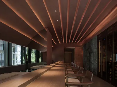 A sleek, modern restaurant bar with wooden seating and stone walls.