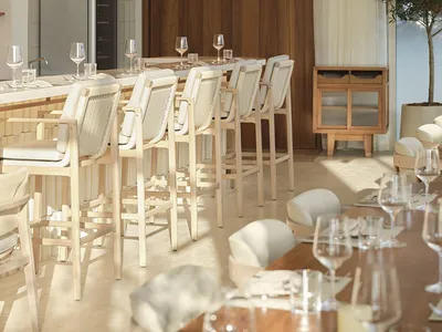 Modern restaurant interior with wooden tables, glassware, and stone accents.