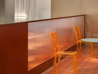A photograph of a modern restaurant interior with transparent acrylic chairs and tables.