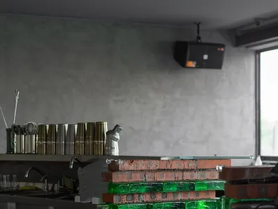Industrial-style restaurant bar with red brick wall and green glass block structure.
