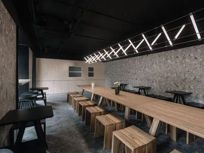 現代工業風格咖啡廳室內，搭配木質餐桌與混凝土牆面