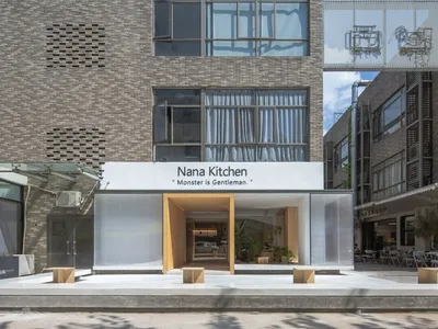 A minimalist restaurant exterior featuring concrete walls and modern design elements.