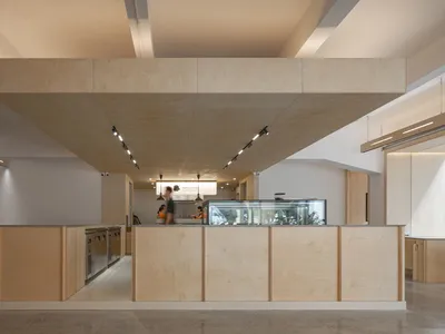 Modern minimalist restaurant interior featuring wooden elements and clean lines.