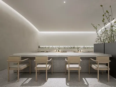 A modern restaurant interior with concrete walls and floors, featuring minimalist furniture and a serene atmosphere.