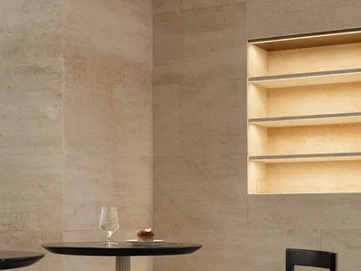 Modern restaurant interior with marble table, concrete floor, and minimalist design.