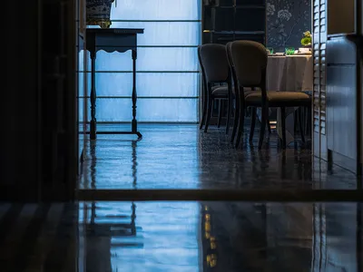 Modern restaurant interior with glass, metal, and wooden decor and lighting.