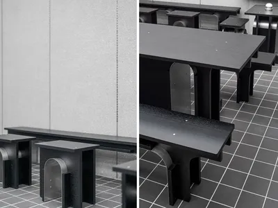 Modern black seating and tables within a restaurant interior setting, featuring minimalist design and sleek finishes.