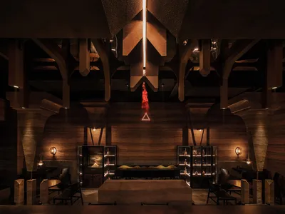 現代工業風餐廳室內，混凝土牆面、高挑天花板與溫暖燈光。