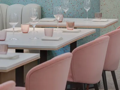 Modern restaurant interior featuring contemporary furniture and decor with terrazzo flooring and walls.