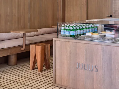 Interior design of a modern restaurant featuring wooden seating and glass elements.