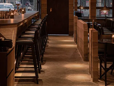 Modern restaurant interior with wooden decor and seating.