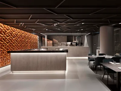 A minimalist restaurant interior with metallic and wooden elements.