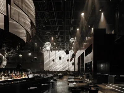 Industrial-style restaurant interior with circular bar and pendant lights.