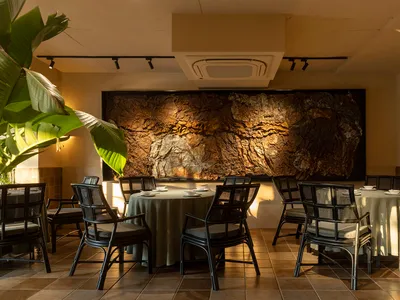 A beautifully designed cafe interior featuring wood, stone, and fabric elements.