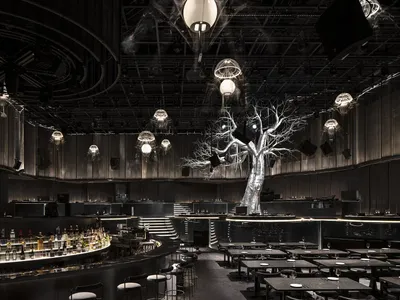 An interior design of a modern restaurant bar with metallic textures and industrial lighting fixtures.
