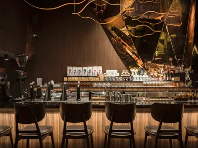 A modern bar interior featuring sleek metal accents and sophisticated lighting.