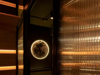 Modern restaurant and bar interior featuring a glass window with a illuminated moon