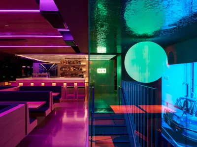 A modern restaurant bar with vibrant lighting and sleek design elements.