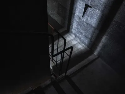 工業風格的混凝土樓梯，搭配金屬扶手，窗外光線灑落其間。
