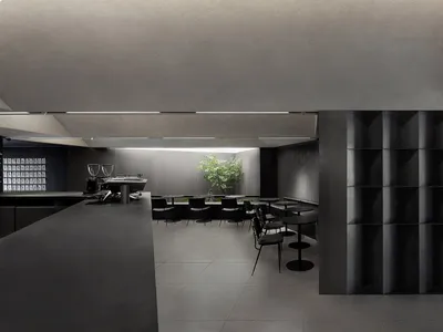 Interior view of a modern restaurant featuring minimalist design with concrete finishes.