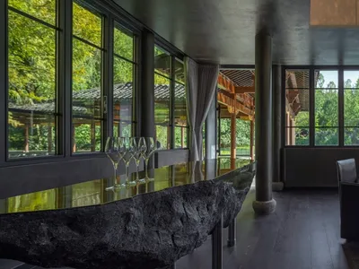 Modern restaurant dining room featuring stone, wood, and glass