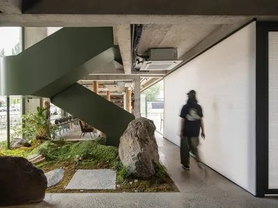 Concrete staircase with green and wooden railings in a modern restaurant interior