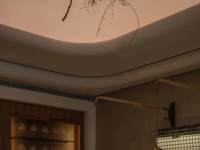 A modern restaurant interior with wooden furniture, minimalistic design, and a warm, inviting atmosphere.