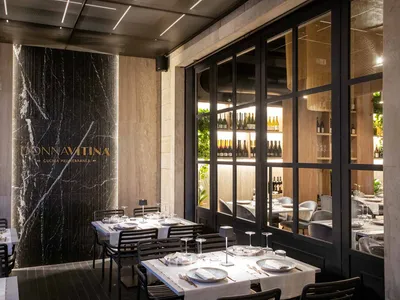 A modern restaurant interior featuring marble, glass, and concrete materials.