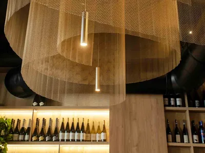 A close-up view of metal mesh ceiling panels in a restaurant setting.