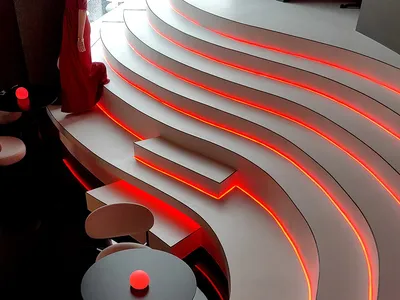 極簡餐廳搭配曲線座椅與發光塑膠點綴。