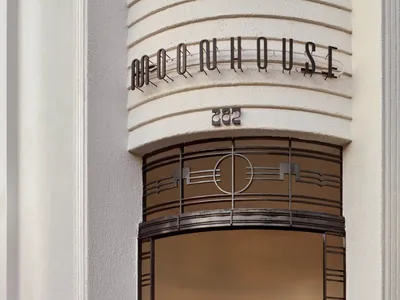 Art Deco entrance to a restaurant with a glass and metal frame.