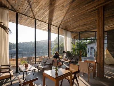 Industrial-style restaurant interior with wooden tables and chairs.