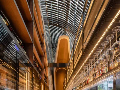 A modern bar with glass, wood, and metal elements.