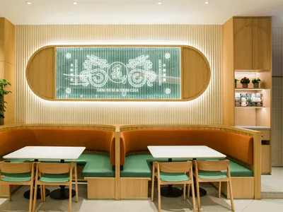 現代工業風餐廳室內，搭配木質家具與木牆板、白桌、綠色座墊，以及灰